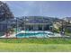 A full view of a screened-in pool area featuring a hot tub and multiple seating areas with lounge chairs at 8518 La Isla Dr, Kissimmee, FL 34747