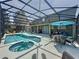 This screened-in pool area has a spa, multiple seating areas, and an umbrella-shaded outdoor table at 8518 La Isla Dr, Kissimmee, FL 34747