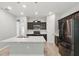 Well-lit kitchen featuring an island with a sink, modern appliances, and dark cabinetry at 10172 Storey Grove Way, Winter Garden, FL 34787