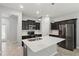 Modern kitchen with stainless steel appliances, an island with sink, pendant lighting, and dark cabinets at 10172 Storey Grove Way, Winter Garden, FL 34787