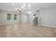 Bright living room with large windows, tile flooring, and stairs, and modern light fixture at 10172 Storey Grove Way, Winter Garden, FL 34787