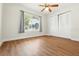 Bright bedroom with hardwood floors, a window view, and a ceiling fan at 10849 William Tell Dr, Orlando, FL 32821