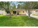 Inviting single-story home with lush green lawn and mature landscaping, creating great curb appeal at 10849 William Tell Dr, Orlando, FL 32821