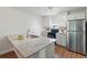 The kitchen features white cabinets, stainless steel refrigerator, and granite countertops at 10849 William Tell Dr, Orlando, FL 32821