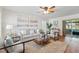 Bright living room with plush rug, comfortable seating, ceiling fan and artwork for a cozy feel at 10849 William Tell Dr, Orlando, FL 32821