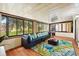 Relaxing sunroom with large windows, comfortable seating, and bright tropical rug at 10849 William Tell Dr, Orlando, FL 32821
