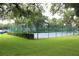 Community tennis court surrounded by lush greenery and secured by a fence at 1108 Northlake Dr # 1108, Sanford, FL 32773