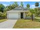Charming single-story home with a well-manicured lawn, paved driveway, and attached garage at 1119 W 7Th St, Sanford, FL 32771