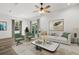 Staged living room featuring wood grain tile with a neutral color scheme and sliding glass doors to the backyard at 1119 W 7Th St, Sanford, FL 32771