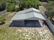 Aerial view of a metal carport and gray siding, surrounded by natural landscape and partial fencing at 11624 Ocklawaha Dr, Leesburg, FL 34788