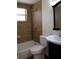 Bathroom featuring a bathtub with tiled walls, a toilet, and sink with a black cabinet at 11624 Ocklawaha Dr, Leesburg, FL 34788