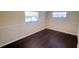 Bedroom featuring two windows for natural light and dark wood flooring at 11624 Ocklawaha Dr, Leesburg, FL 34788
