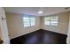 Spacious bedroom with dark wood floors and two windows, creating a bright and airy atmosphere at 11624 Ocklawaha Dr, Leesburg, FL 34788