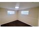 Bedroom featuring two windows for natural light and dark wood flooring at 11624 Ocklawaha Dr, Leesburg, FL 34788