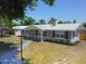 Attractive single story home with gray and white exterior, lamp post and well manicured landscaping at 11624 Ocklawaha Dr, Leesburg, FL 34788