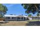 Charming home featuring a metal roof, stone accents, and mature trees in a well-manicured front yard at 11624 Ocklawaha Dr, Leesburg, FL 34788