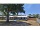 Charming home featuring a metal roof, neutral paint, and mature trees in a well-manicured front yard at 11624 Ocklawaha Dr, Leesburg, FL 34788