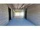 Open garage interior with unfinished wood walls and concrete floor extending to backyard at 11624 Ocklawaha Dr, Leesburg, FL 34788