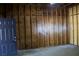 Unfinished garage interior showcasing wooden walls, concrete floor, and an exterior door at 11624 Ocklawaha Dr, Leesburg, FL 34788