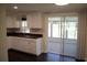 Beautiful kitchen with white cabinetry, modern backsplash, stainless steel sink, and access to the screened lanai at 11624 Ocklawaha Dr, Leesburg, FL 34788