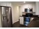 Kitchen with stainless steel refrigerator, white cabinetry, dark countertops, and stainless steel stove and microwave at 11624 Ocklawaha Dr, Leesburg, FL 34788