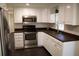 Well-lit kitchen featuring stainless steel appliances, white cabinetry, and dark countertops at 11624 Ocklawaha Dr, Leesburg, FL 34788