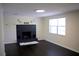 Bright living room featuring a decorative fireplace, dark wood floors, and a large window at 11624 Ocklawaha Dr, Leesburg, FL 34788