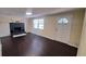Cozy living room with dark wood floors, a decorative fireplace, and a window for natural light at 11624 Ocklawaha Dr, Leesburg, FL 34788