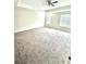 Spacious bedroom featuring neutral carpet, ceiling fan, and natural light from two windows at 11982 Travel Aly, Orlando, FL 32832