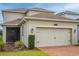 A beautiful suburban home featuring a two-car garage and a screened in porch at 11982 Travel Aly, Orlando, FL 32832