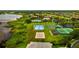 Aerial view features an ice rink, sports courts, and a pool, all surrounded by lush landscaping and a lake nearby at 1208 Castleport Rd, Winter Garden, FL 34787