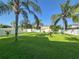 A green backyard is surrounded by a white fence with palm trees and bright green grass at 1208 Castleport Rd, Winter Garden, FL 34787