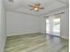 Spacious bedroom with wood-look flooring and sliding door access to balcony at 1208 Castleport Rd, Winter Garden, FL 34787
