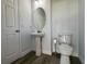 Powder room featuring a toilet and pedestal sink, an oval mirror, neutral paint, and modern floors at 1208 Castleport Rd, Winter Garden, FL 34787