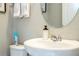 Close-up of the half bathroom vanity featuring chrome faucet, round mirror and linen hand towels at 12259 Bracco St, Winter Garden, FL 34787