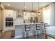Bright kitchen featuring stainless appliances, white cabinets, pendant lighting, and an island with bar stool seating at 12259 Bracco St, Winter Garden, FL 34787