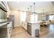 Spacious kitchen featuring stainless steel appliances, an island with a sink, and modern pendant lighting at 12259 Bracco St, Winter Garden, FL 34787