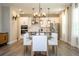 Open-concept kitchen and dining area with modern pendant lights, white cabinets, and natural light at 12259 Bracco St, Winter Garden, FL 34787