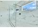 Sleek bathroom showcasing a glass-enclosed shower with marble-look tile and a window at 13075 Sunrise Harvest Dr, Winter Garden, FL 34787