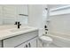 Modern bathroom with gray vanity, white countertop, tub with tiled wall, and sleek fixtures at 13075 Sunrise Harvest Dr, Winter Garden, FL 34787