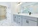 Modern bathroom featuring double vanity, gray cabinets, and marble-look tile flooring at 13075 Sunrise Harvest Dr, Winter Garden, FL 34787