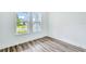 Bedroom featuring wood-look flooring and two large windows that provide plenty of natural light at 13075 Sunrise Harvest Dr, Winter Garden, FL 34787