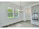 Open dining room with lots of natural light and gray cabinets with stainless steel appliances at 13075 Sunrise Harvest Dr, Winter Garden, FL 34787