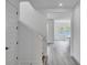Clean, bright entryway featuring light gray wood-look floors, a staircase, and an open view into the living area at 13075 Sunrise Harvest Dr, Winter Garden, FL 34787