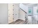 Hallway featuring wood-look flooring, an adjacent bathroom, and a staircase with black iron railing at 13075 Sunrise Harvest Dr, Winter Garden, FL 34787