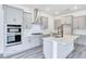 Well-equipped kitchen boasting gray cabinets, stainless steel appliances, a center island, and a modern range hood at 13075 Sunrise Harvest Dr, Winter Garden, FL 34787