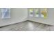 Bright living room featuring light gray wood-look floors, neutral walls, and ample natural light from the windows at 13075 Sunrise Harvest Dr, Winter Garden, FL 34787