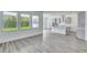 Open-concept living area with gray wood-look floors, recessed lighting, and a view of the modern kitchen at 13075 Sunrise Harvest Dr, Winter Garden, FL 34787