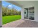 Covered brick patio offers a seamless transition to a well-maintained lawn and lush green space at 13075 Sunrise Harvest Dr, Winter Garden, FL 34787