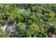 Aerial view showcasing a home surrounded by lush greenery, with a glimpse of a nearby pond and mature trees at 1315 E 24Th St, Sanford, FL 32771